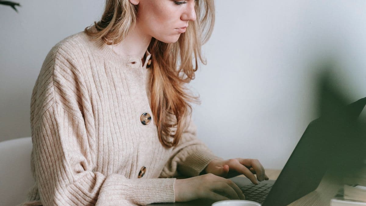 Junge Frau lernt konzentriert zu Hause am Laptop, Jura im Fernstudium