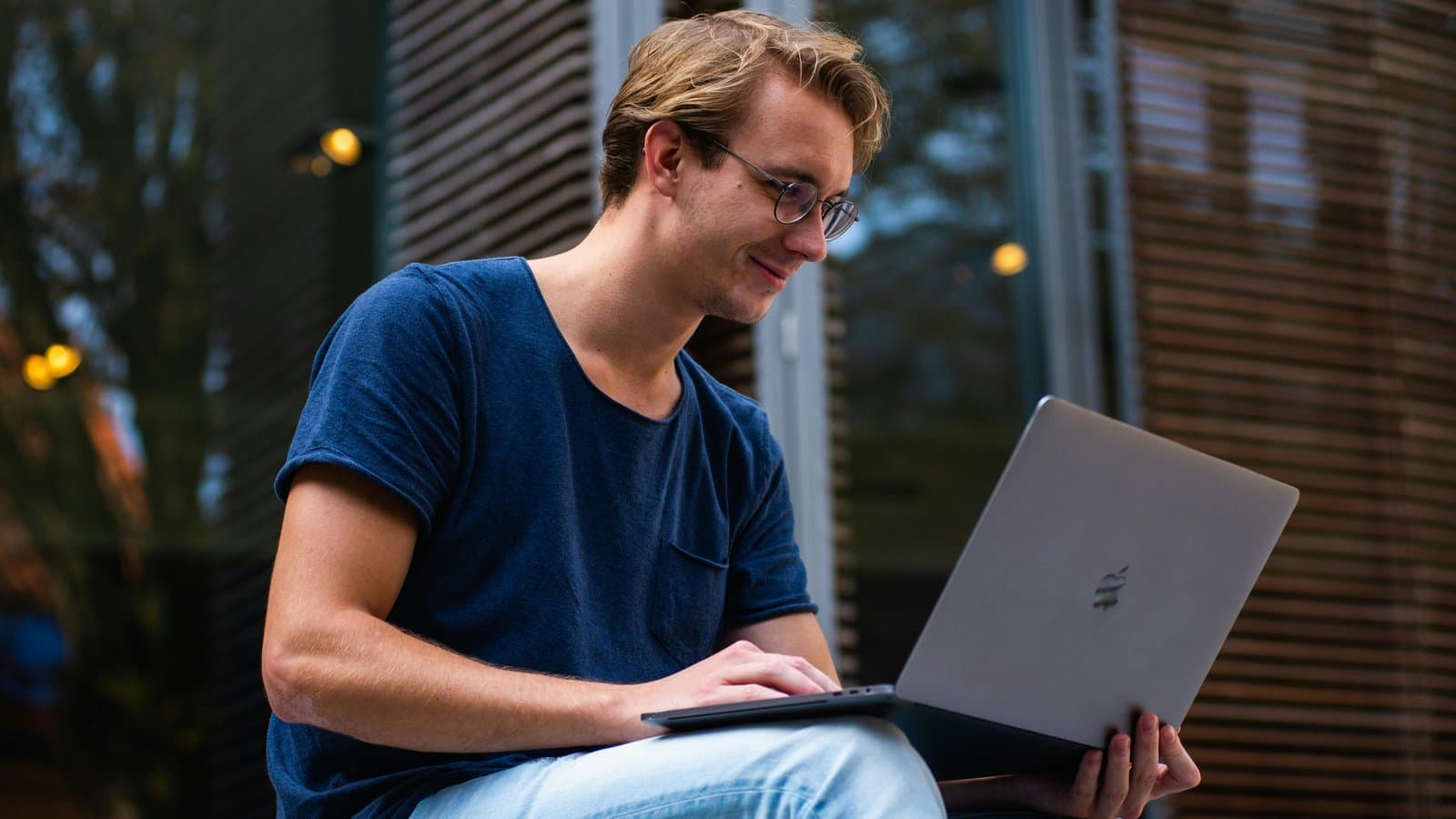 Junger Mann mit Laptop, Sinnbild für kostenlose Online-Tools im Jurastudium