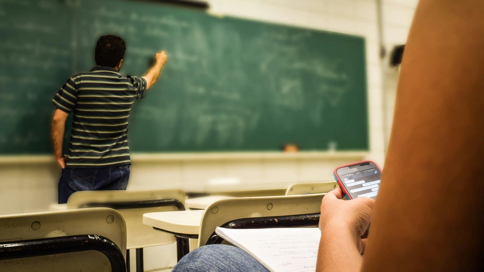 Person schreibt an einer Tafel, Sinnbild für Repetitorium und Selbststudium in der Examensvorbereitung