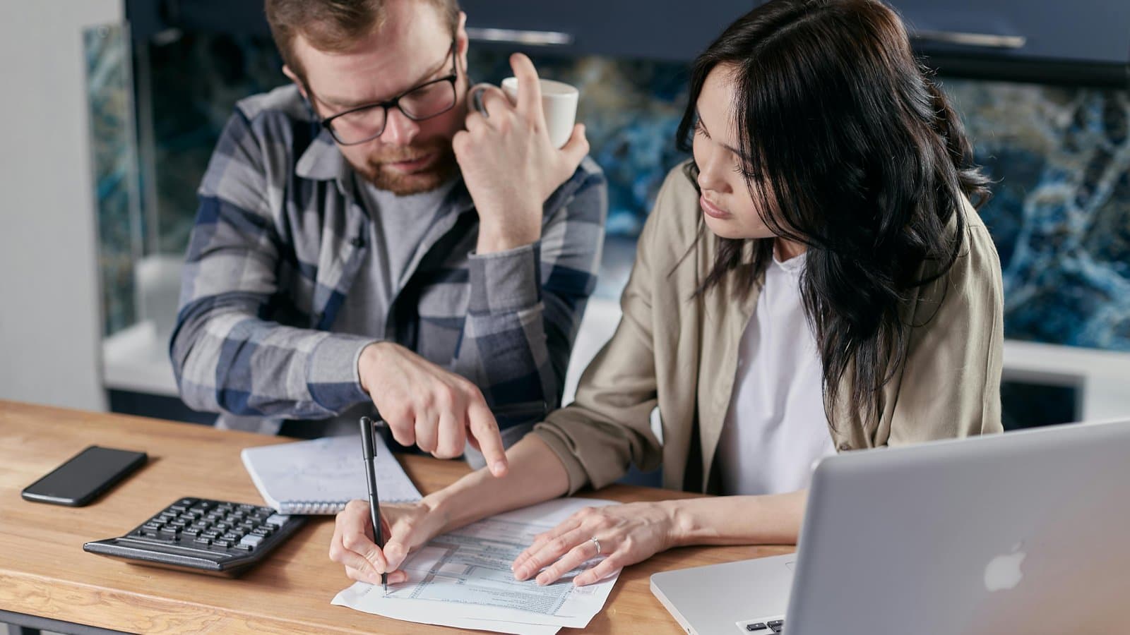 Zwei Personen arbeiten gemeinsam am Schreibtisch, Sinnbild für Leistungs- und Schutzpflichten nach § 241 BGB