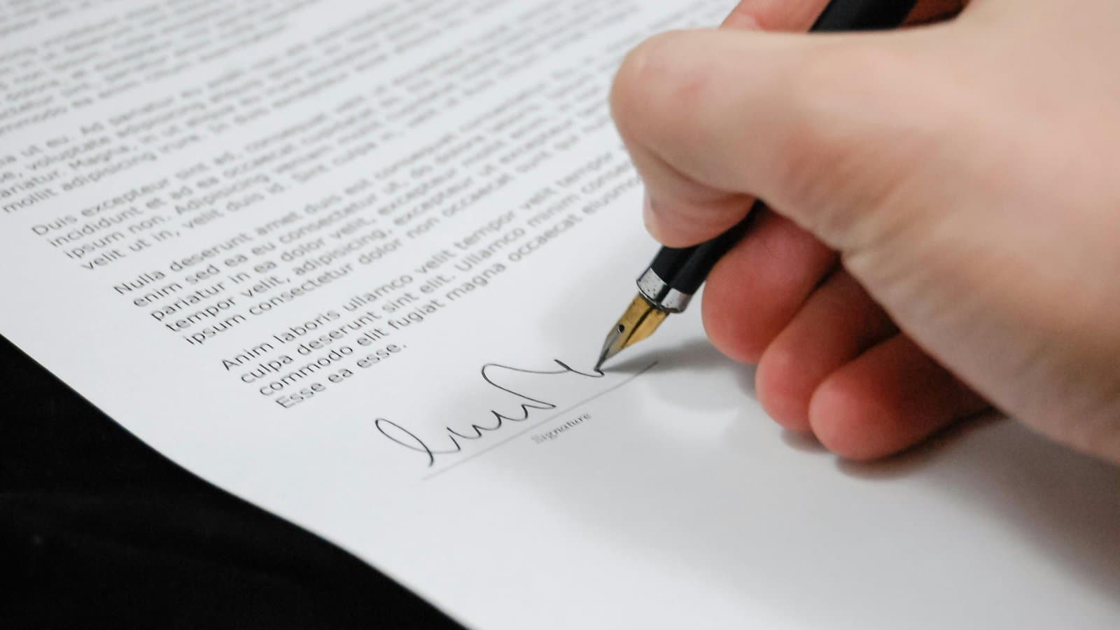 Hand unterschreibt ein Dokument mit Füller, Sinnbild für Formbedürftigkeit und Formnichtigkeit