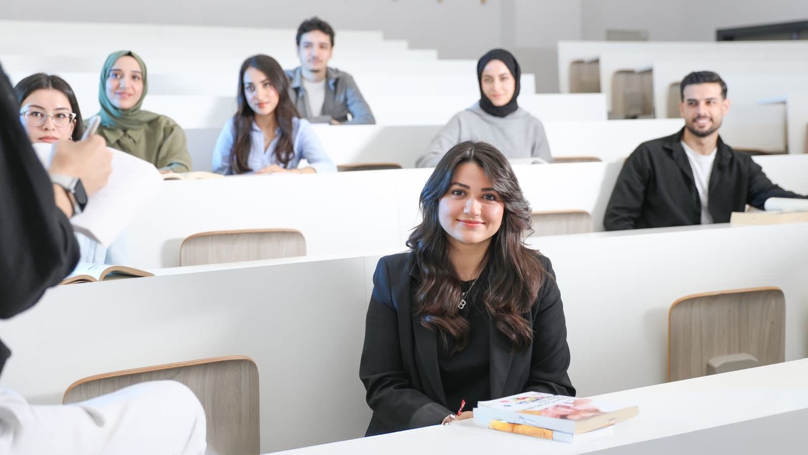 Studierende sitzen in einem hellen Hörsaal einer Universität