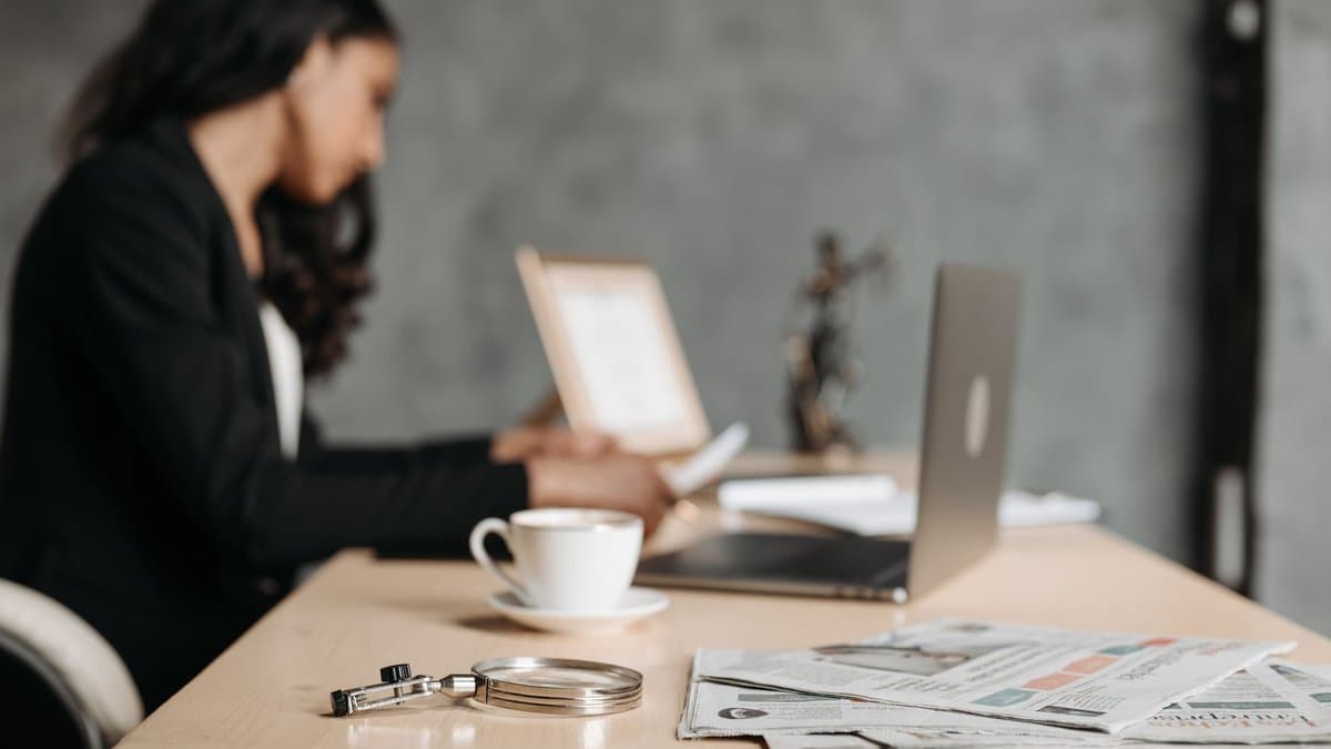 Juristin am Schreibtisch mit Laptop und Dokumenten in einem modernen Büro