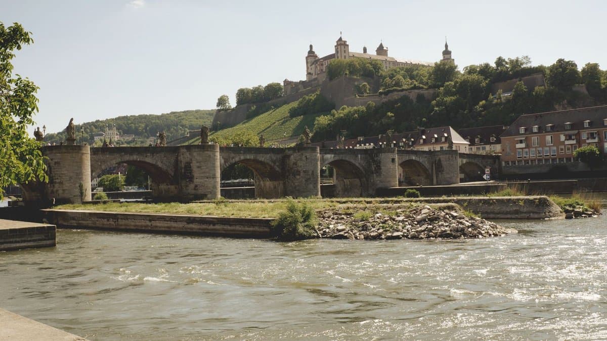 Alte Mainbrücke über den Main, dahinter die Festung Marienberg über den Weinbergen
