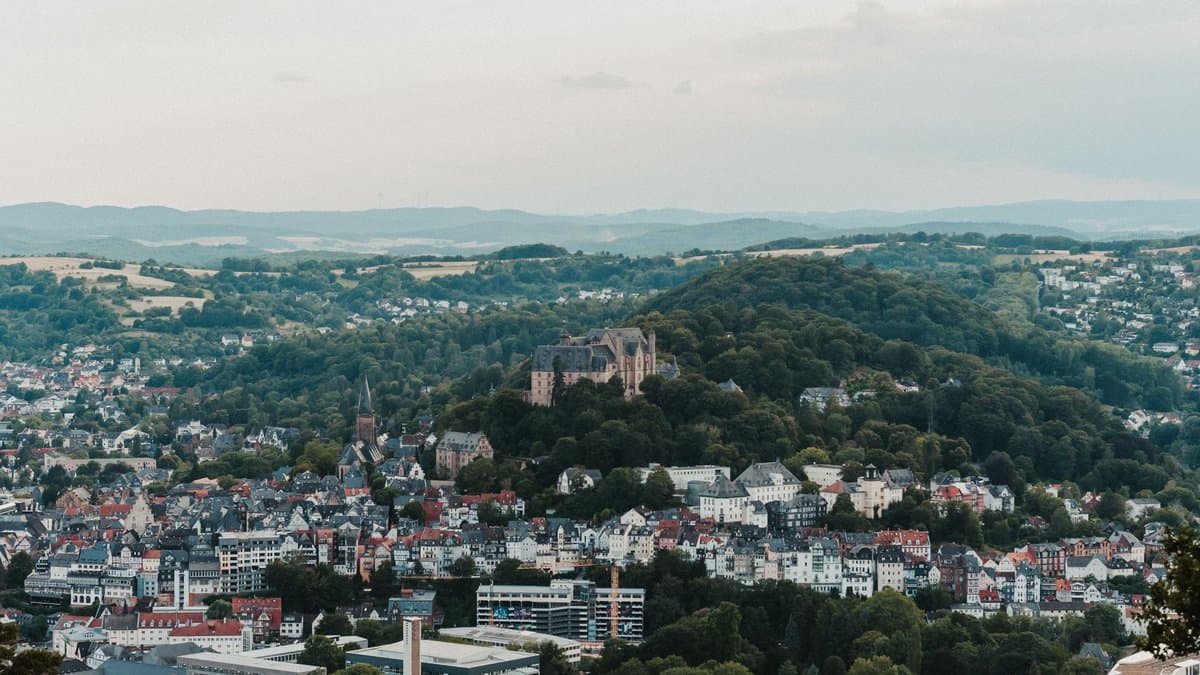Blick über die Stadt Marburg mit dem Landgrafenschloss auf dem bewaldeten Hügel