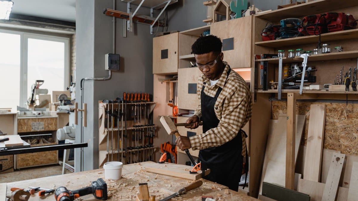 Tischler arbeitet in seiner Werkstatt an einem Holzwerkstück auf der Werkbank
