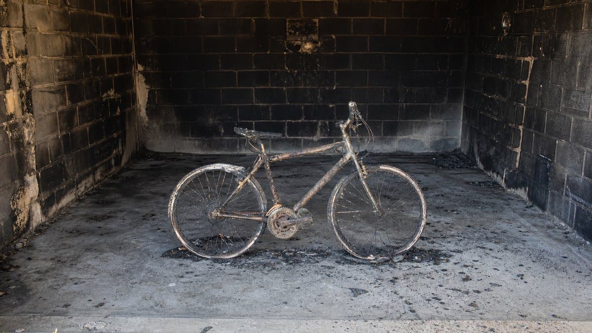 Ausgebranntes Fahrrad in einer verrußten Garage