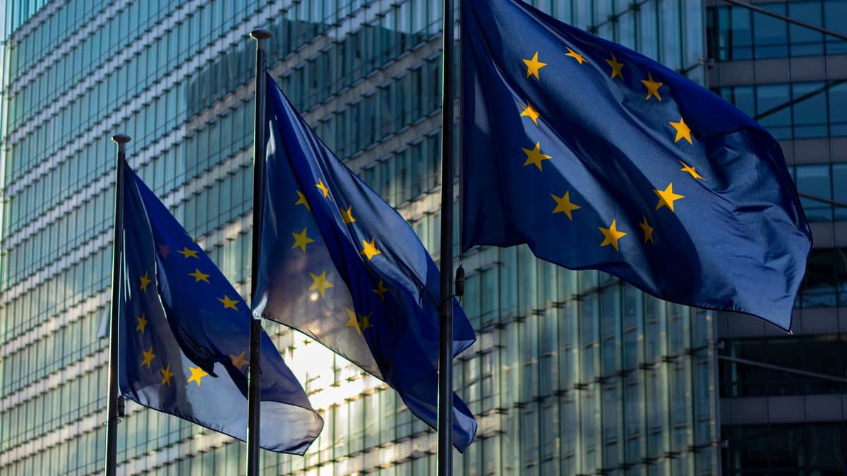 Drei Flaggen der Europäischen Union wehen vor der Glasfassade eines Institutionsgebäudes