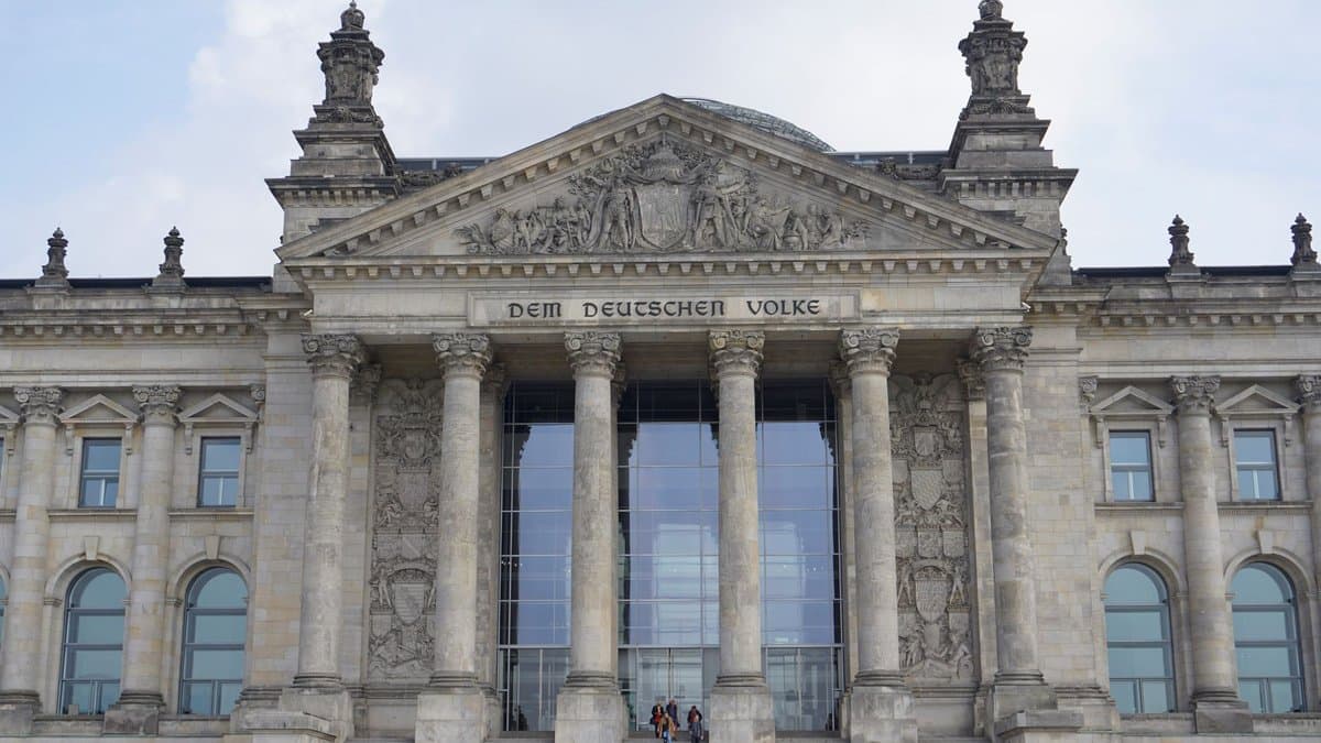 Das Reichstagsgebäude in Berlin von vorn, Säulenportikus mit Giebelrelief und Freitreppe bei Tageslicht