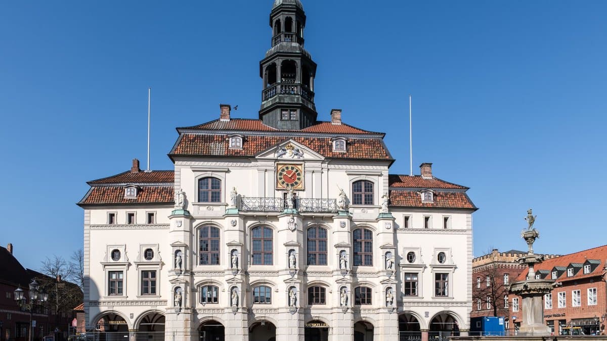 Barockes Rathaus einer deutschen Stadt mit Turm, Wappen und Arkaden an einem klaren Tag