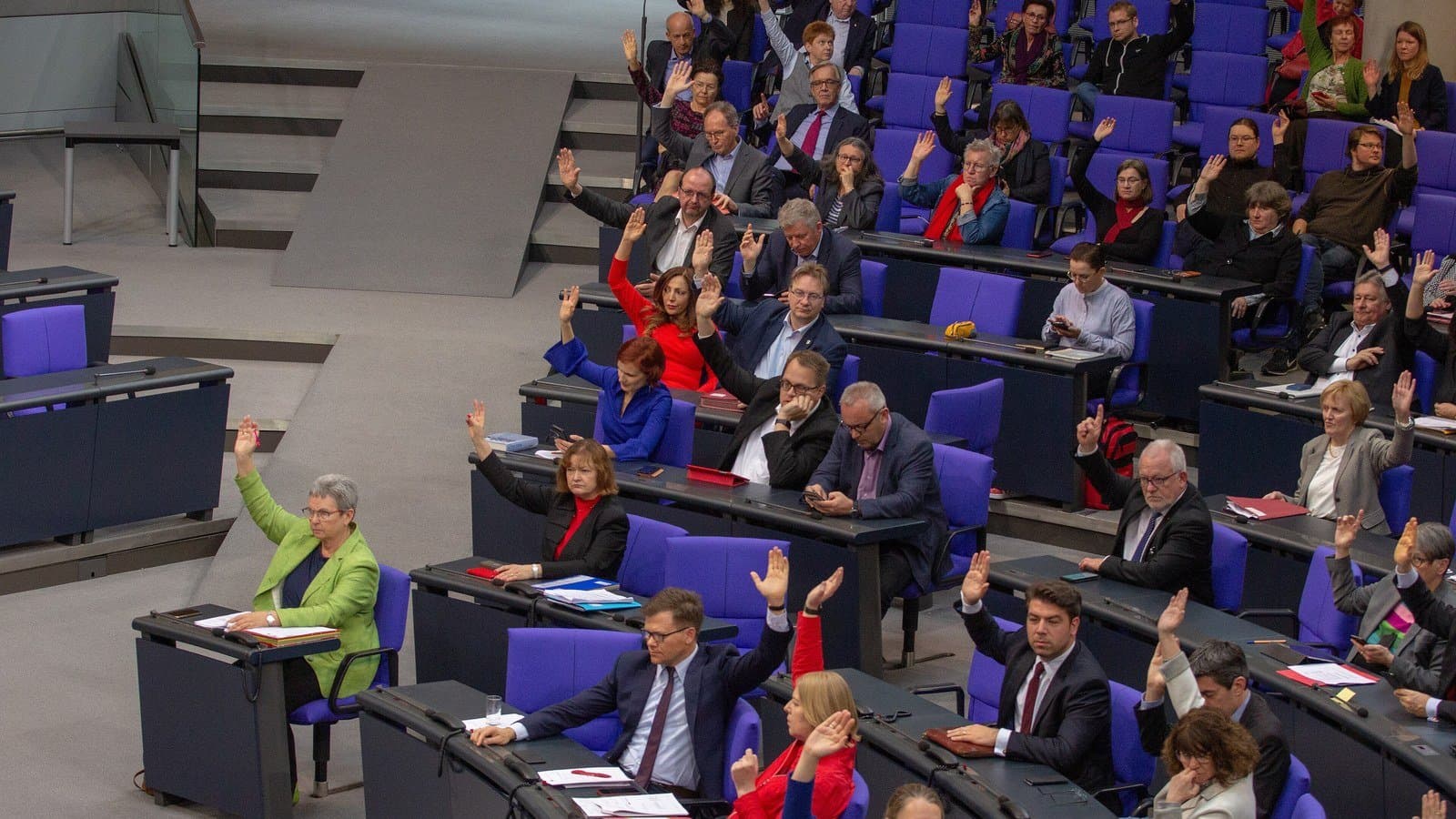 Abgeordnete in den ansteigenden Rängen des Plenarsaals des Deutschen Bundestages, ein Teil hat zur Abstimmung die Hand erhoben