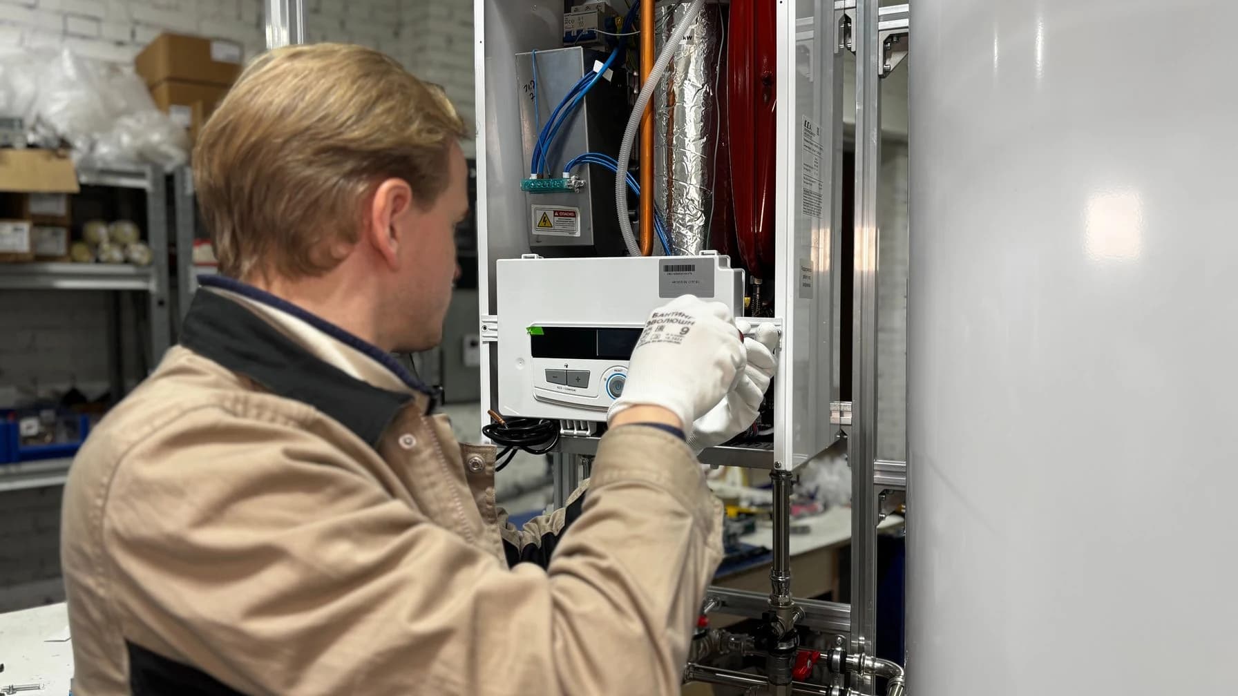Heizungsbauer montiert eine Gastherme und prüft die Anschlüsse