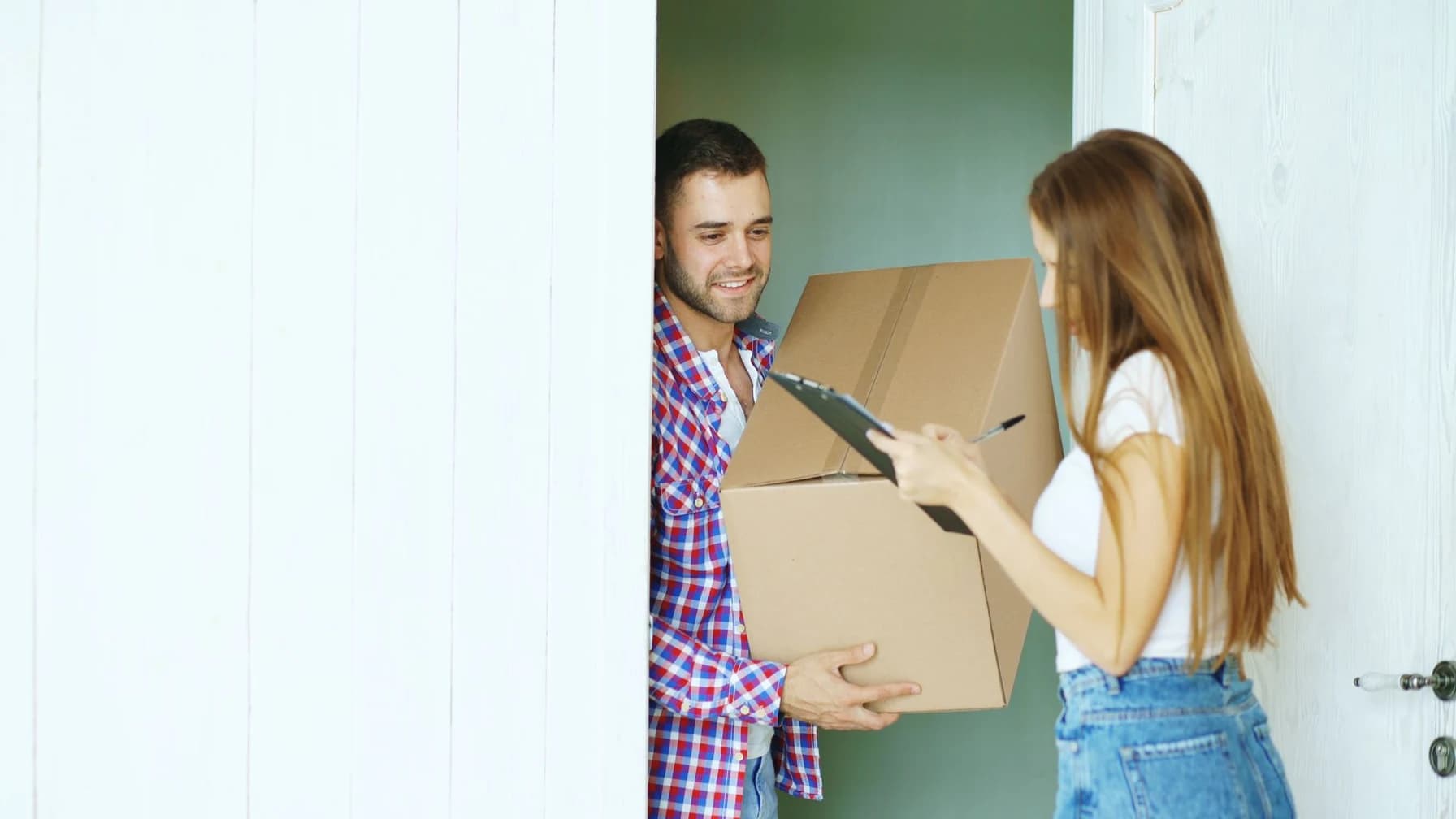 Kurier übergibt einer Kundin ein Paket an der Wohnungstür