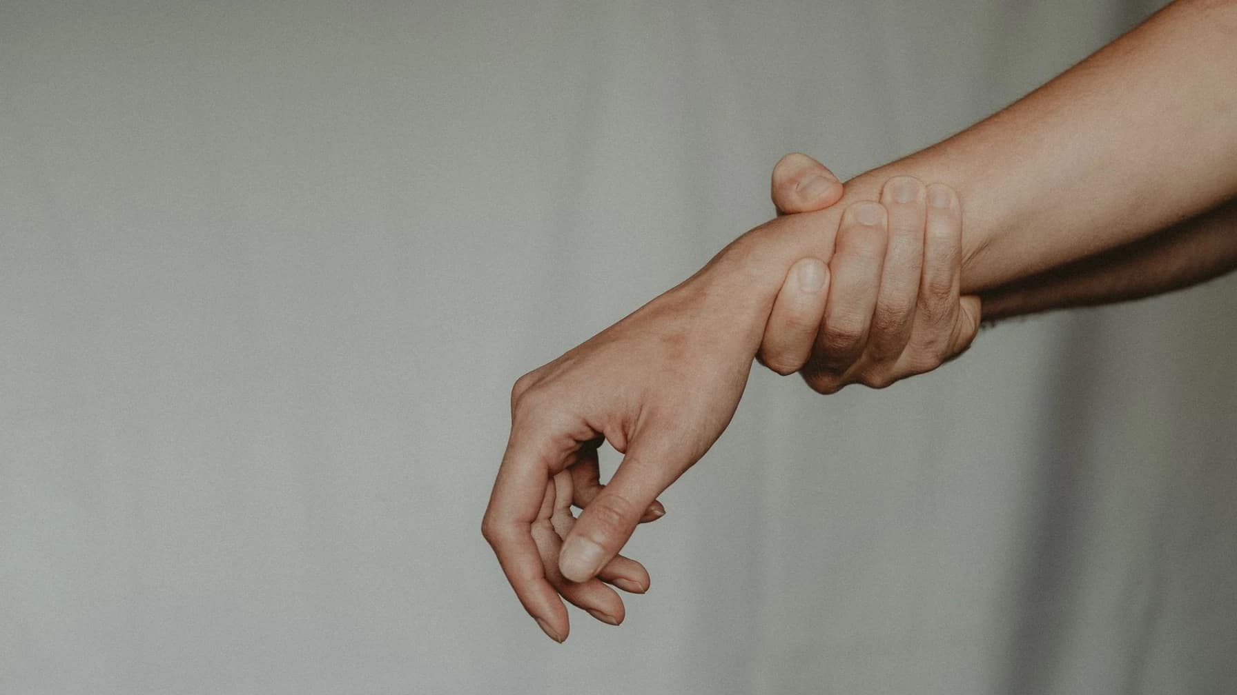 Nahaufnahme einer Hand, die das Handgelenk einer anderen Person fest umklammert