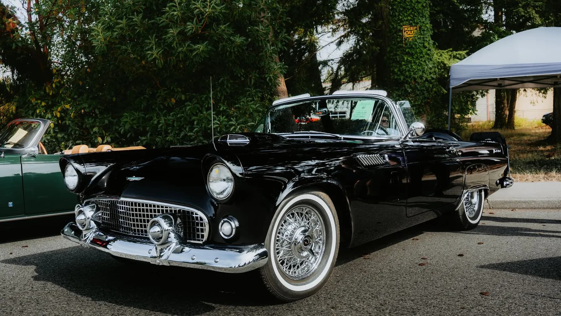 Schwarzes Oldtimer-Cabrio auf einer Oldtimer-Ausstellung im Freien