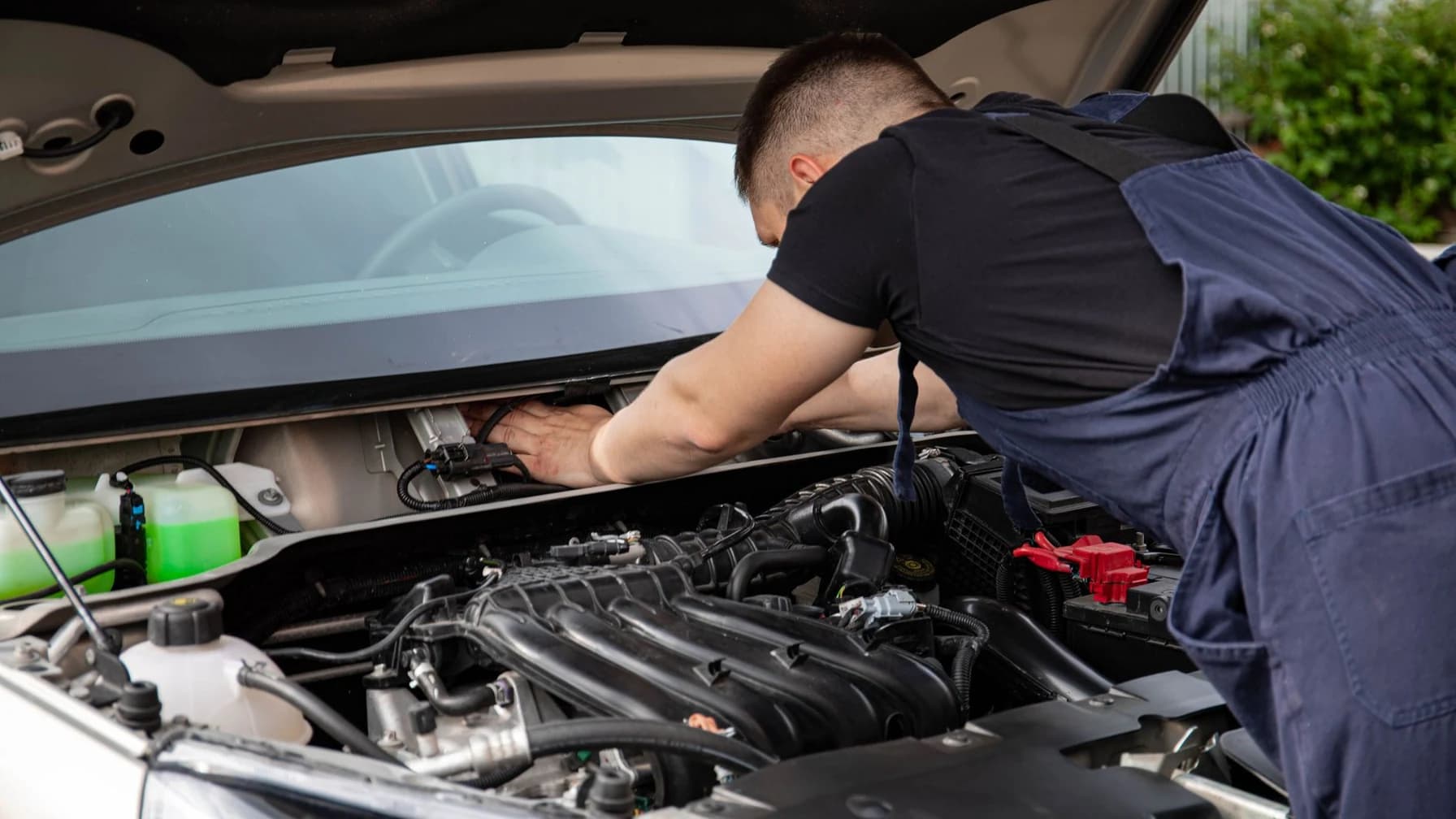 Nahaufnahme eines Automotors mit den Händen eines Mechanikers bei der Reparatur.