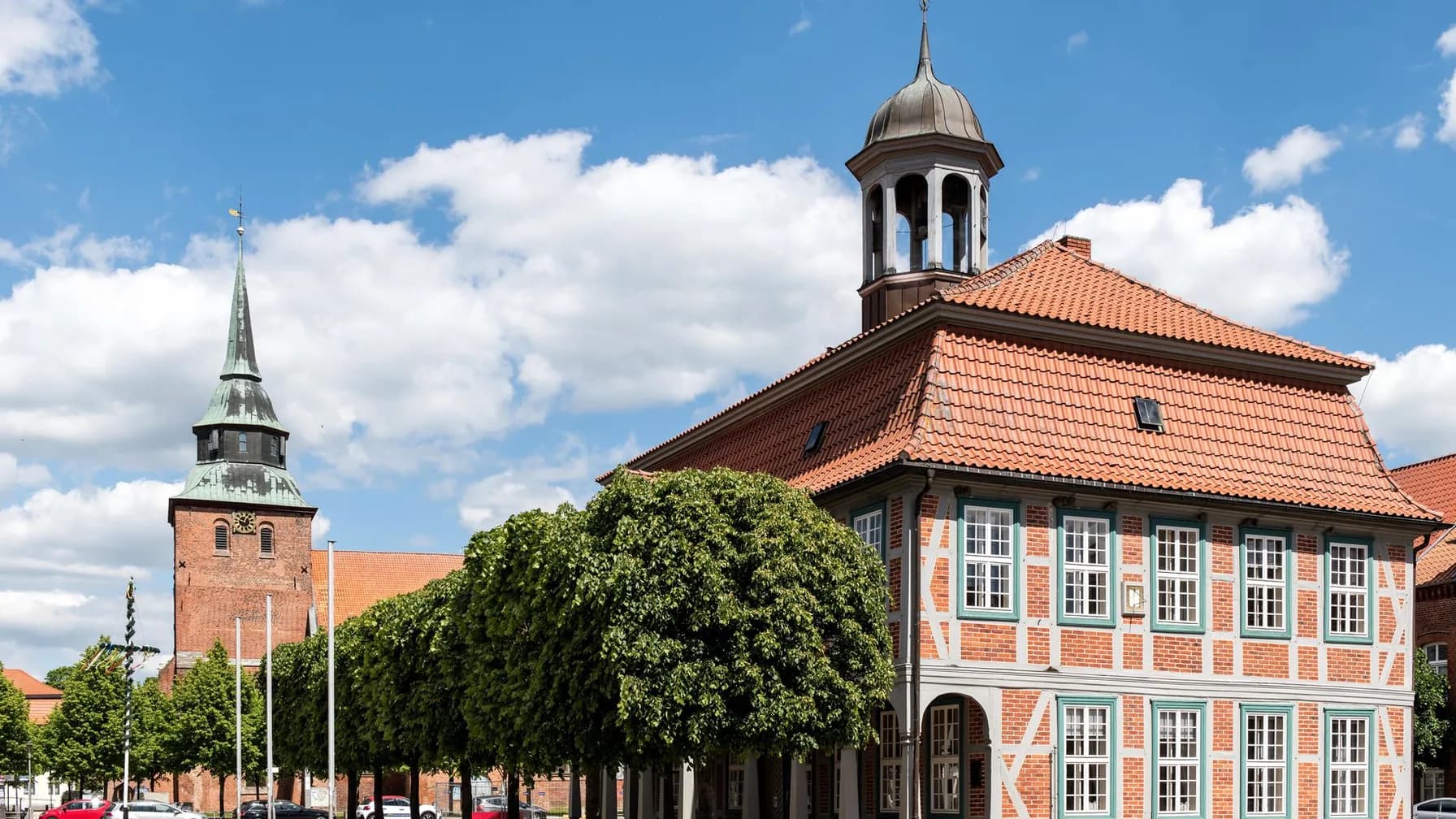 Historisches Rathaus mit Kirchturm am Marktplatz einer norddeutschen Kleinstadt